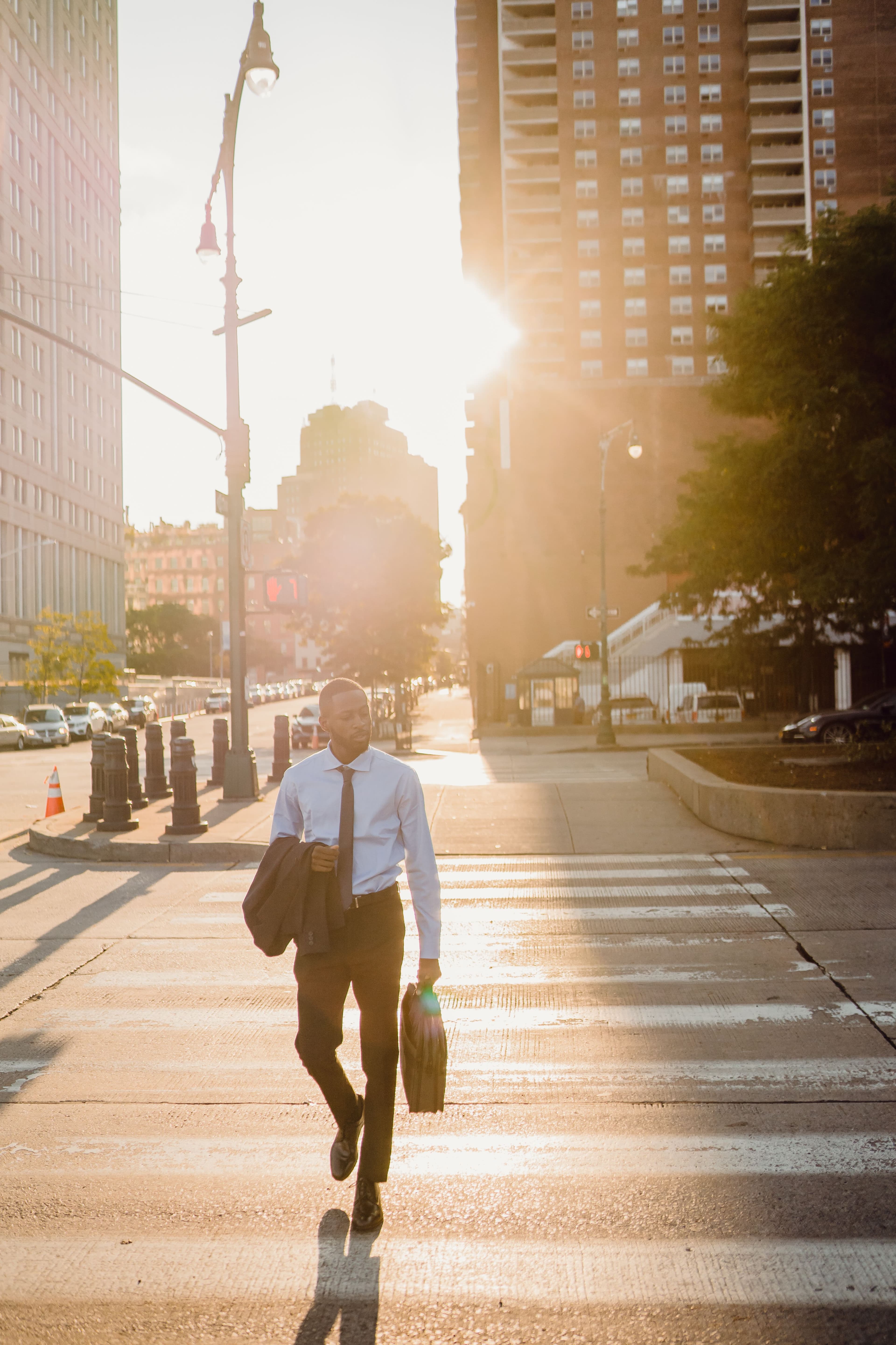 A business professional walking across a city crosswalk.